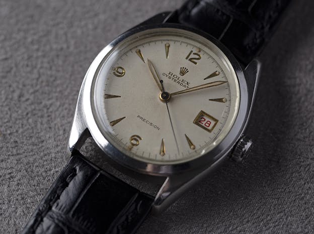 Vintage Rolex Oysterdate Precision wristwatch with leather strap and silver dial.